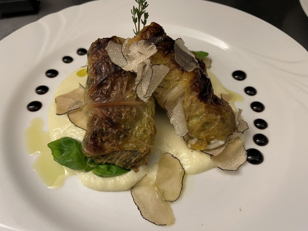 Gefüllter Wirsingkohl mit Trüffel-Hackfleisch auf einer cremigen Parmesan-Creme garniert mit frischen Trüffelscheiben im Restaurant Roma
