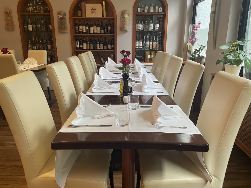 Stilvoll gedeckter langer Tisch für Gruppen und Feiern im italienischen Restaurant Roma